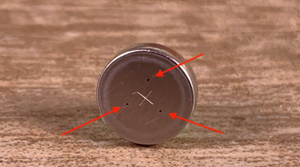 Bei diesem Foto sieht man die drei Öffnungen, durch die die Luft in die Knopfzelle gelangt, wenn man die Schutzfolie abzieht.