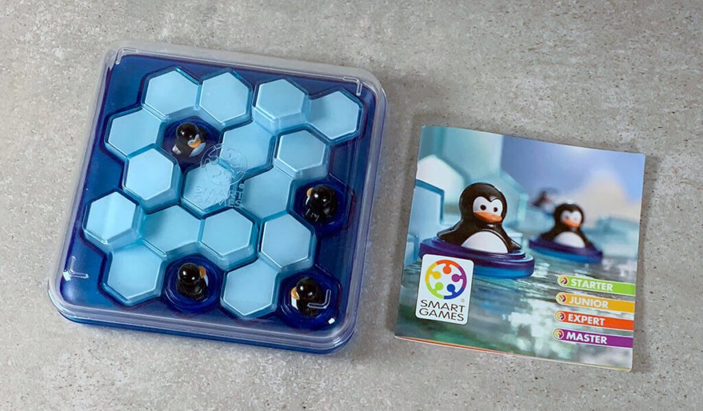 Die Spielfiguren, Eisberge und Anleitung passen auf das Spielbrett und können mit einem Deckel verschlossen werden – perfekt zum Verstauen und mitnehmen.