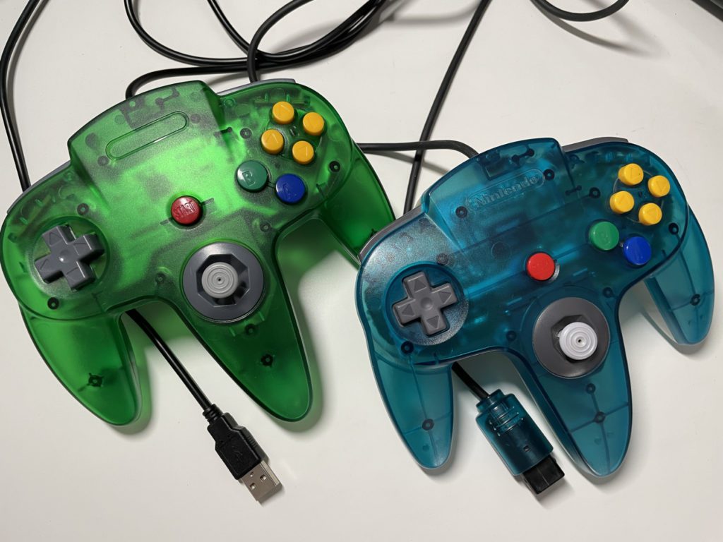Der miadore Retro 64 Controller mit USB-Anschluss (grün, links) ist dem originalen N64-Controller von Nintendo (blau, rechts) sehr gut nachempfunden. Das Spielgefühl ist damit ebenfalls sehr nahe am Original.