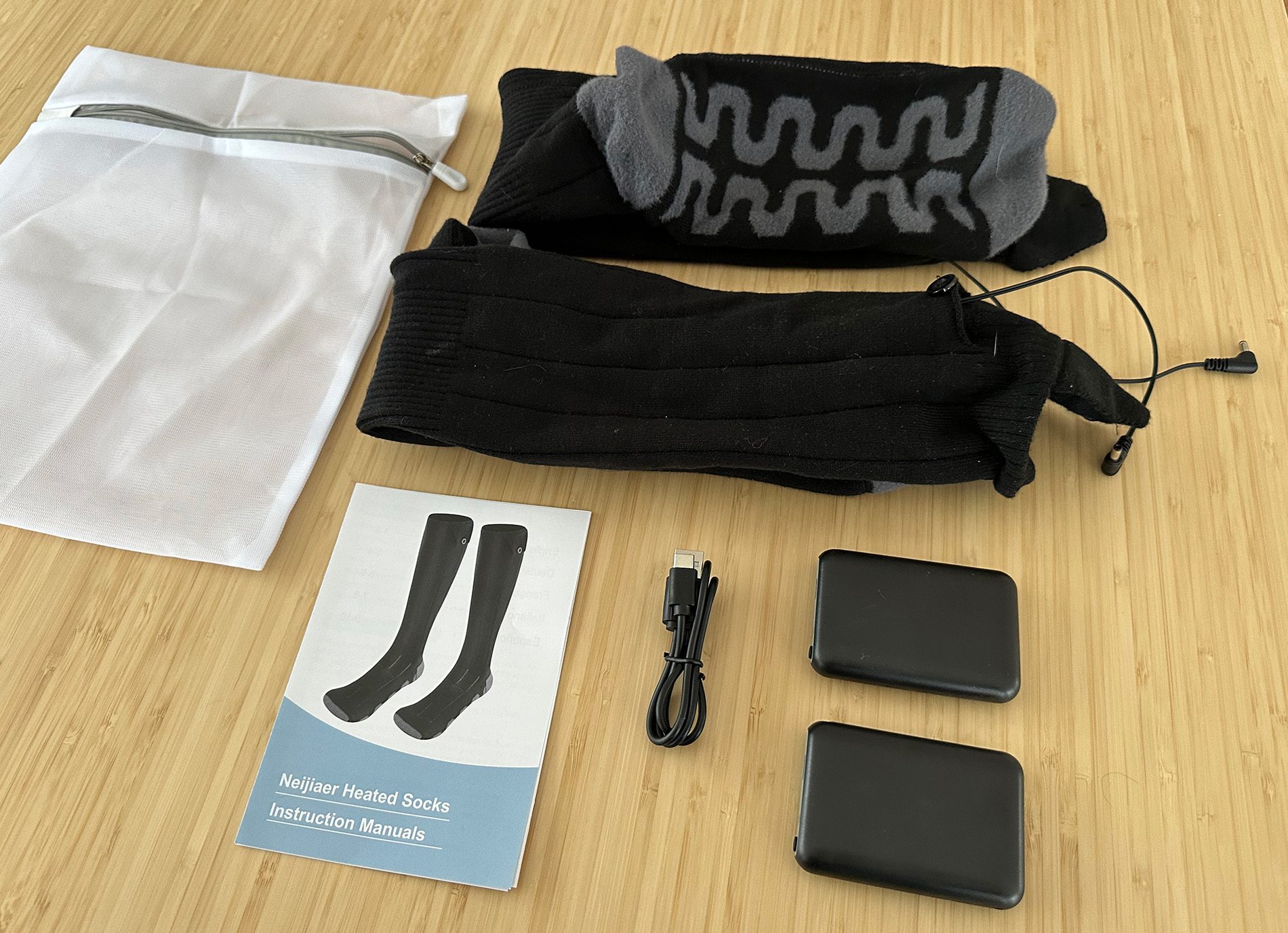 Der Lieferumfang der beheizbaren Socken: Eine Tasche für die Wäsche, die beiden Socken, zwei Powerbanks, ein Ladekabel und die Anleitung (Fotos: Sir Apfelot).