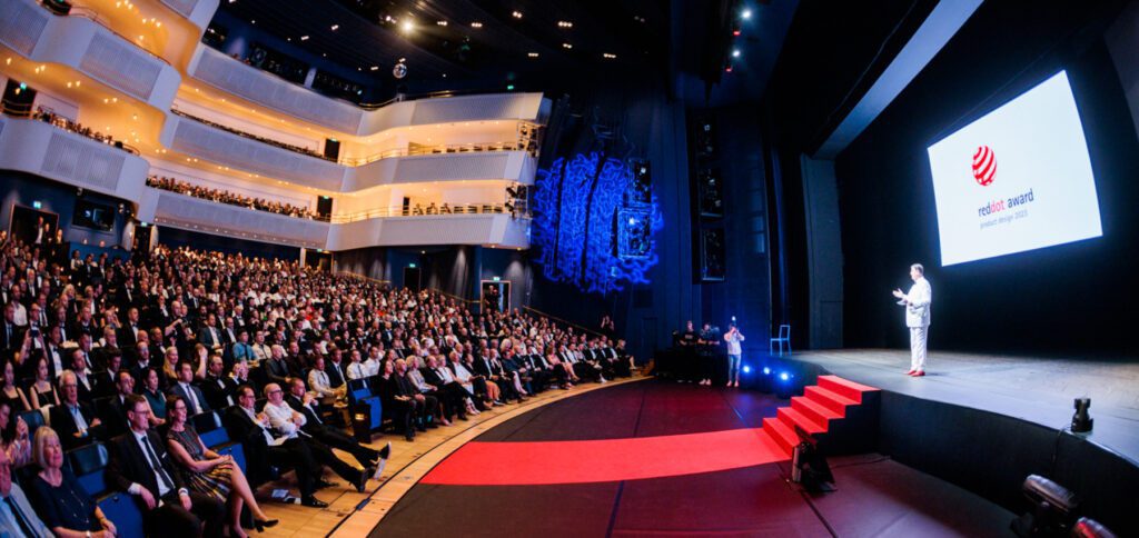 CEO Peter Zec auf der Bühne des Essener Opernhauses im Rahmen der Red Dot Gala 2023. Wie mannigfach der Designpreis verliehen und wie das ganze finanziert wird, das lest ihr hier. Bildquelle: Pressemitteilung auf red-dot.org
