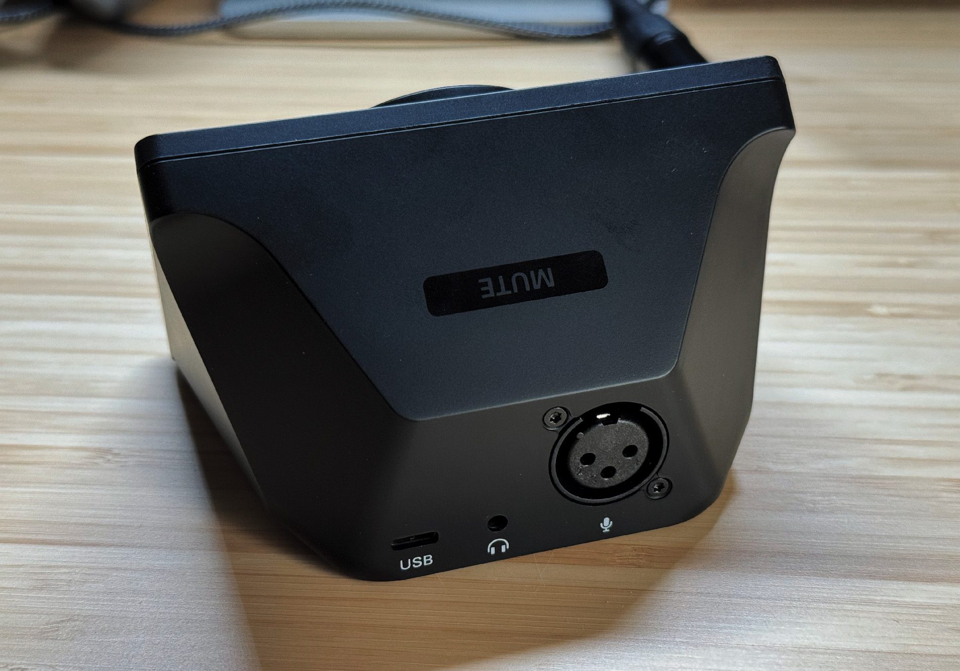 Auf der Rückseite findet man eine XLR-Buchse, eine USB-C-Buchse und einen Kopfhörerausgang. Obendrauf ist der Mute-Button zu erkennen.